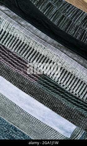 Warm knitted textile stack with the different texture in grey color palette close up Stock Photo