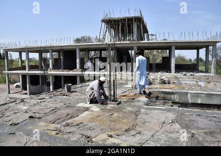 (210728) -- KHYBER DISTRICT, July 28, 2021 (Xinhua) -- Laborers work at a construction site of one of the 50 schools being gifted by the Chinese government to the children in Khyber district of Pakistan's northwestern Khyber Pakhtunkhwa province, July 5, 2021. TO GO WITH 'Feature: China's support helps Pakistani children embrace better education' (Photo by Saeed Ahmad/Xinhua) Stock Photo