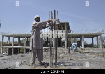 (210728) -- KHYBER DISTRICT, July 28, 2021 (Xinhua) -- Laborers work at a construction site of one of the 50 schools being gifted by the Chinese government to the children in Khyber district of Pakistan's northwestern Khyber Pakhtunkhwa province, July 5, 2021. TO GO WITH 'Feature: China's support helps Pakistani children embrace better education' (Photo by Saeed Ahmad/Xinhua) Stock Photo