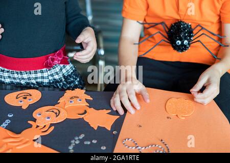 Halloween kids craft preparations. Little children doing crafts at home. Holiday DIY concept. Stock Photo