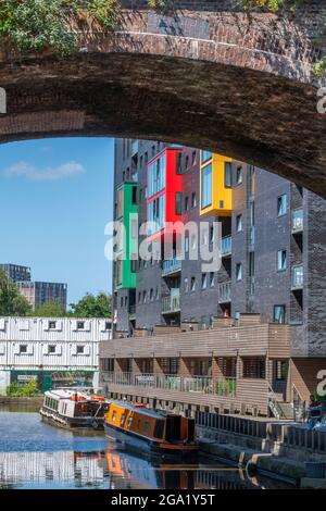 narrowboats and barges moored under a bridge on the bridgewater canal in central manchester, uk. contrasting styles of architecture in industrial city Stock Photo