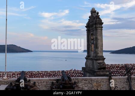 Herceg Novi, Montenegro - July 17, 2021 Ancient anchors and cannons stored in the Maritime Museum, an old bell tower Stock Photo