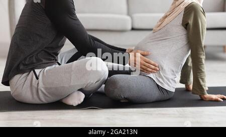 Cropped Image Of Caring Husband Touching His Pregnant Muslim Wife's Belly Stock Photo