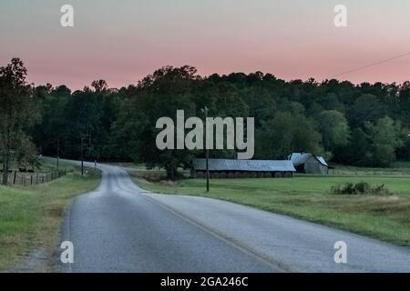 View down an empty country road in rural Alabama at twilight. Stock Photo