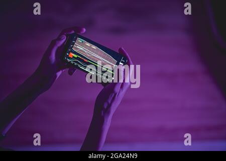Close up shot of person using his phone to trade Stock Photo
