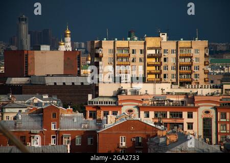 Yellow houses and roofs on the deep grey pre-storm sky. Birds-eye view the center of Moscow Garden Ring at sunset. Various styles of Moscow architectu Stock Photo