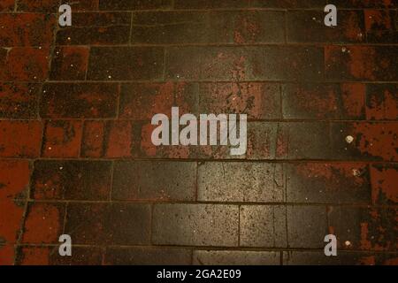 Old floor with red glazed clay tiles, very worn, from a warehouse of a building in Madrid, spain. Texture and background Stock Photo