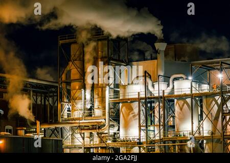 Processing plant with emissions glowing with light at night; Nebraska, United States of America Stock Photo