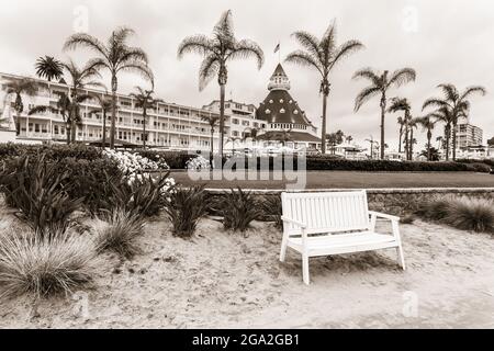 Wooden bench on the beach in front of the iconic Hotel del Coronado; Coronado, California, United States of America Stock Photo