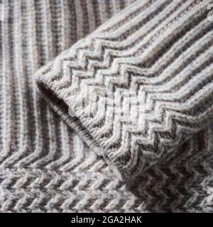 Extreme close-up of the cuff of a grey knit sweater; Studio Stock Photo