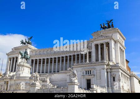 The iconic Victor Emmanuel II National Monument in white marble against a blue sky with a bronze, equestrian sculpture of Victor Emmanuel II in the... Stock Photo