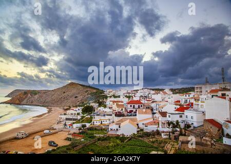 Dramatic grey cloud formation swirling above the traditional fishing village of Burgau in the municipality of Vila do Bispo in the Western Region o... Stock Photo