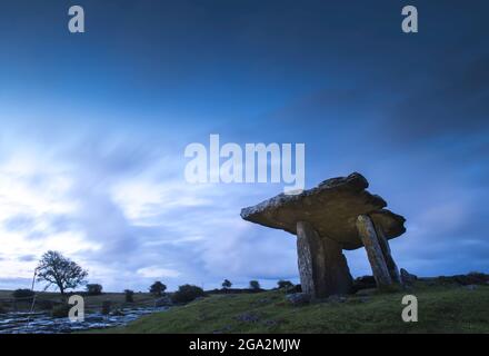 The megalithic portal tomb of Poulnabrone Dolmen with rocky karst landscape of the Burren in the blue light of dawn; County Clare, Ireland Stock Photo