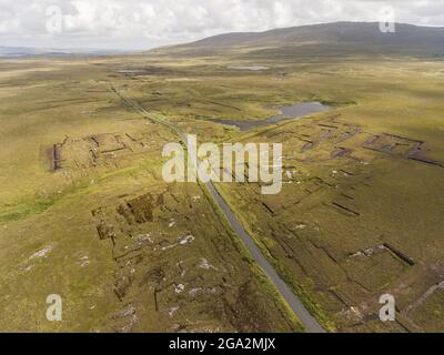 Aerial View of the Bog Road (Bothar na Scrathog) leading through cut peat bogs in  Connemara; Carraroe, County Galway, Ireland Stock Photo