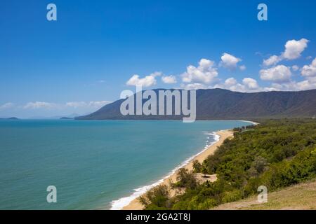 Scenic view overlooking the sandy beach, mountains and vegetation where the Daintree Rainforest meets the Coral Sea on the Pacific Ocean Coast in E... Stock Photo