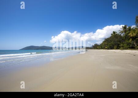 Pristine sand of Thornton Beach with the surf of the Coral Sea meets the Daintree Rainforest on the Pacific Ocean Coast in Eastern Kuku Yalanji Stock Photo