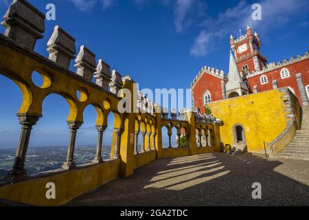 Overlooking Sintra through the colorful arches and columns of Queen's Terrace with the red Clock Tower in the background at Palacio Da Pena Stock Photo