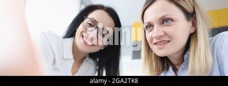 Two young women are sitting at laptop Stock Photo