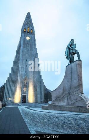 The Hallgrimskirkja illuminated, Lutheran cathedral with a statue of the famous explorer Leif Erikson in front that predates the church, the first ... Stock Photo