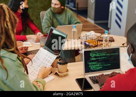Hands of young contemporary software developer of African ethnicity touching keys of laptop keypad while working over new program Stock Photo