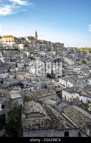 Cityscape of the mountaintop town of Sassi di Matera and its ancient cave dwellings with the bell tower of the Matera Cathedral overlooking the city Stock Photo