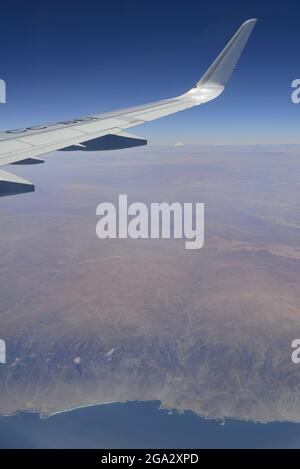 Close-up of the wing of an airplane, flying over the empty dessert of Northern Chile from Andes to sea, 130 miles where nobody lives Stock Photo