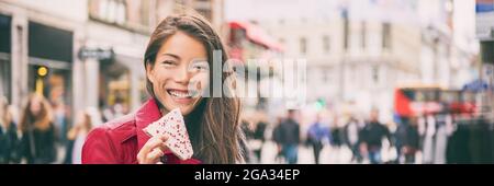 Copenhagen travel lifestyle woman tourist eating typical danish food pastry called Hindbaersnitter, Raspberry slice or shortbread, sweet cookie from Stock Photo