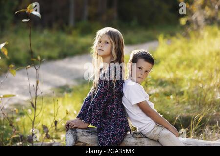 Portrait of a young brother and sister together outdoors in a city park during the fall season; Edmonton, Alberta, Canada Stock Photo