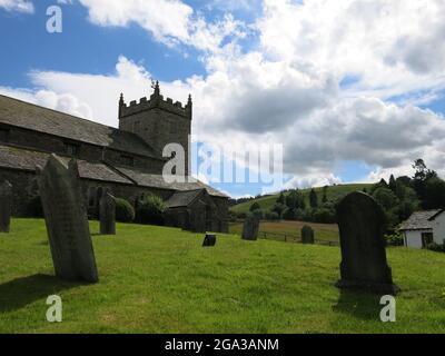 Beautiful summer's day in the Lake District with the church of St Michael's and its gravestones nestled on the hilltop at the village of Hawkshead. Stock Photo