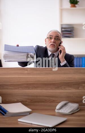 Aged businessman employee sitting at workplace Stock Photo