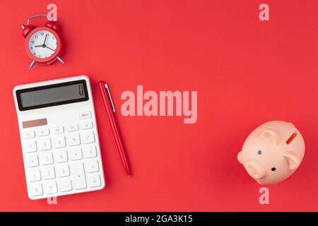 Pen, calculator, alarm clock pig piggy bank. Stock Photo