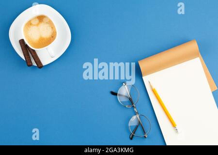 Open notepad with pencil, cup of coffee, glasses. Stock Photo