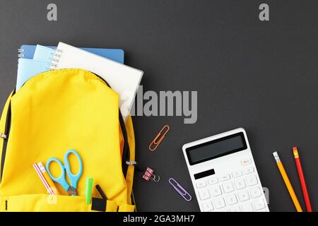 School supplies in a yellow backpack. Stock Photo