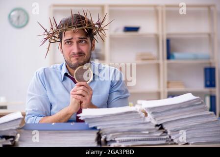 Young businessman employee wearing prickly wreath on head Stock Photo