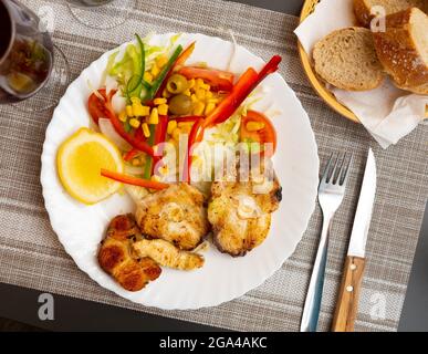 Oven baked hake with vegetable garnish Stock Photo