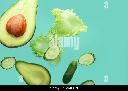 Flying green vegetables on color background Stock Photo