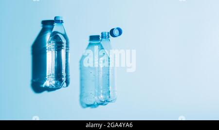 Plastic bottles with water and empty used blue background. Recycling recyclable plastic. Environmental protection Stock Photo