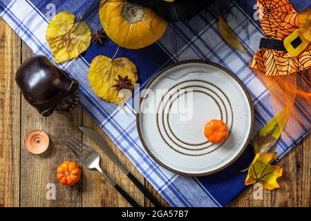 Halloween day decoration party, Halloween festive table setting with pumpkins and autumn leaves. Top view flat lay background. Stock Photo