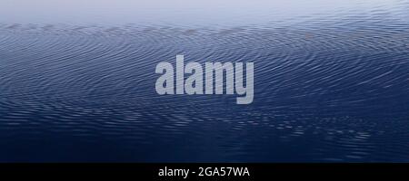 Hypnotic geometric ripples in calm crystal waters Stock Photo
