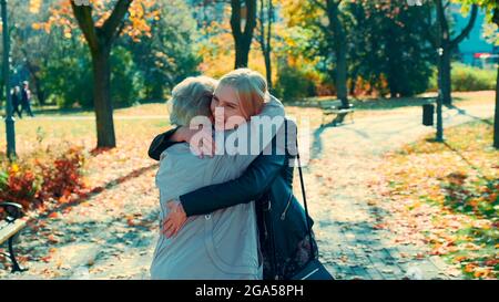 Grandmother and granddaughter hugging each other in park. They happy to spend time together and walking outdoors. Stock Photo