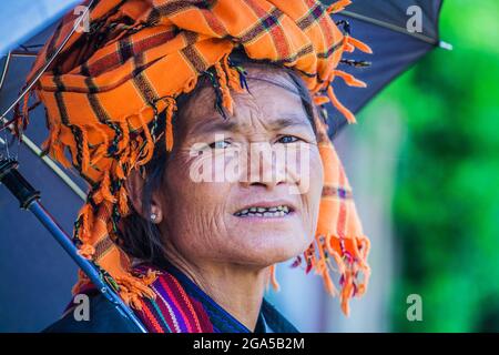 Market trader from Pa'o (Pa-o) ethnic hill tribe wearing orange turban selling vegetables in Kalaw, Shan State, Myanmar Stock Photo