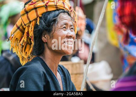 Market trader from Pa'o (Pa-o) hill tribe wearing orange turban selling vegetables in Kalaw, Shan State, Myanmar Stock Photo