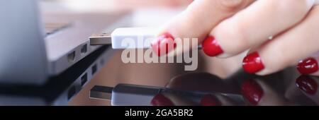 Female hand inserting usb flash into laptop closeup Stock Photo