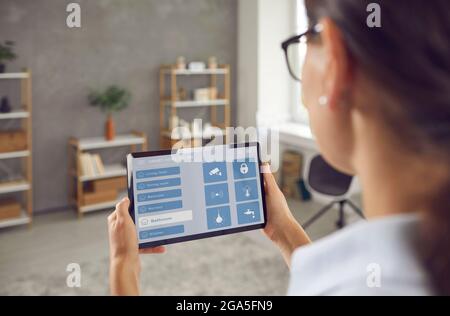 Woman controlling system of her Smart House using modern app on her digital tablet Stock Photo