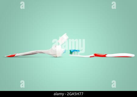 Toothpaste and toothbrush tubes isolated on green pastel colors background. Stock Photo