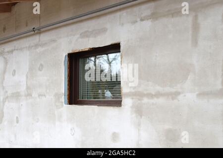 Plastered house wall and window in the wall Stock Photo