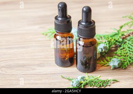 Juniper essential oil in a small bottle. Selective focus. Stock Photo