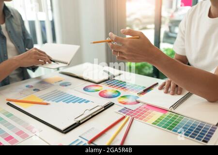 two designers discussing on the color tone for the excellent visual work. Stock Photo