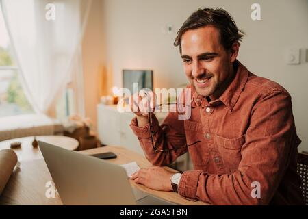 Caucasian male student working from home interacting on video call with classmates using laptop Stock Photo