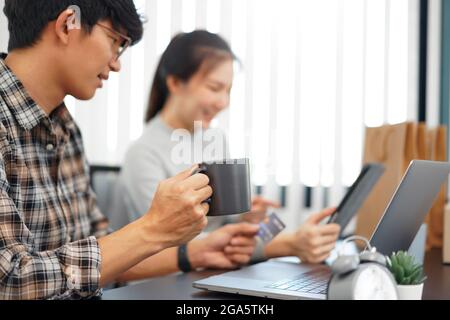 Shopping online concept a couple choosing recommended products with appealing promotions shown in online shop on a tablet device. Stock Photo